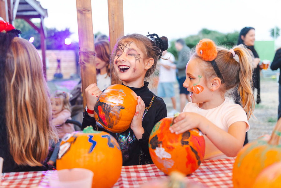 Children decorating pumpkins at a craft table