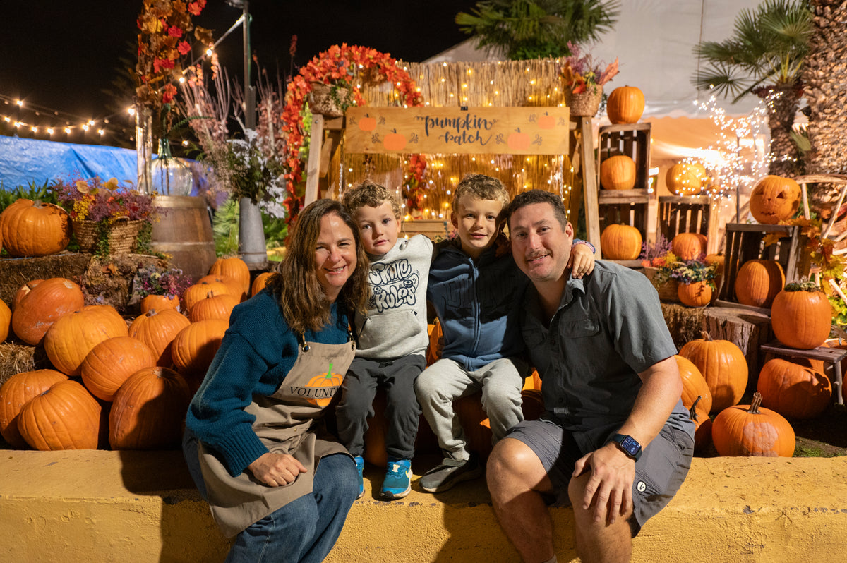 A family smiling together in the pumpkin field